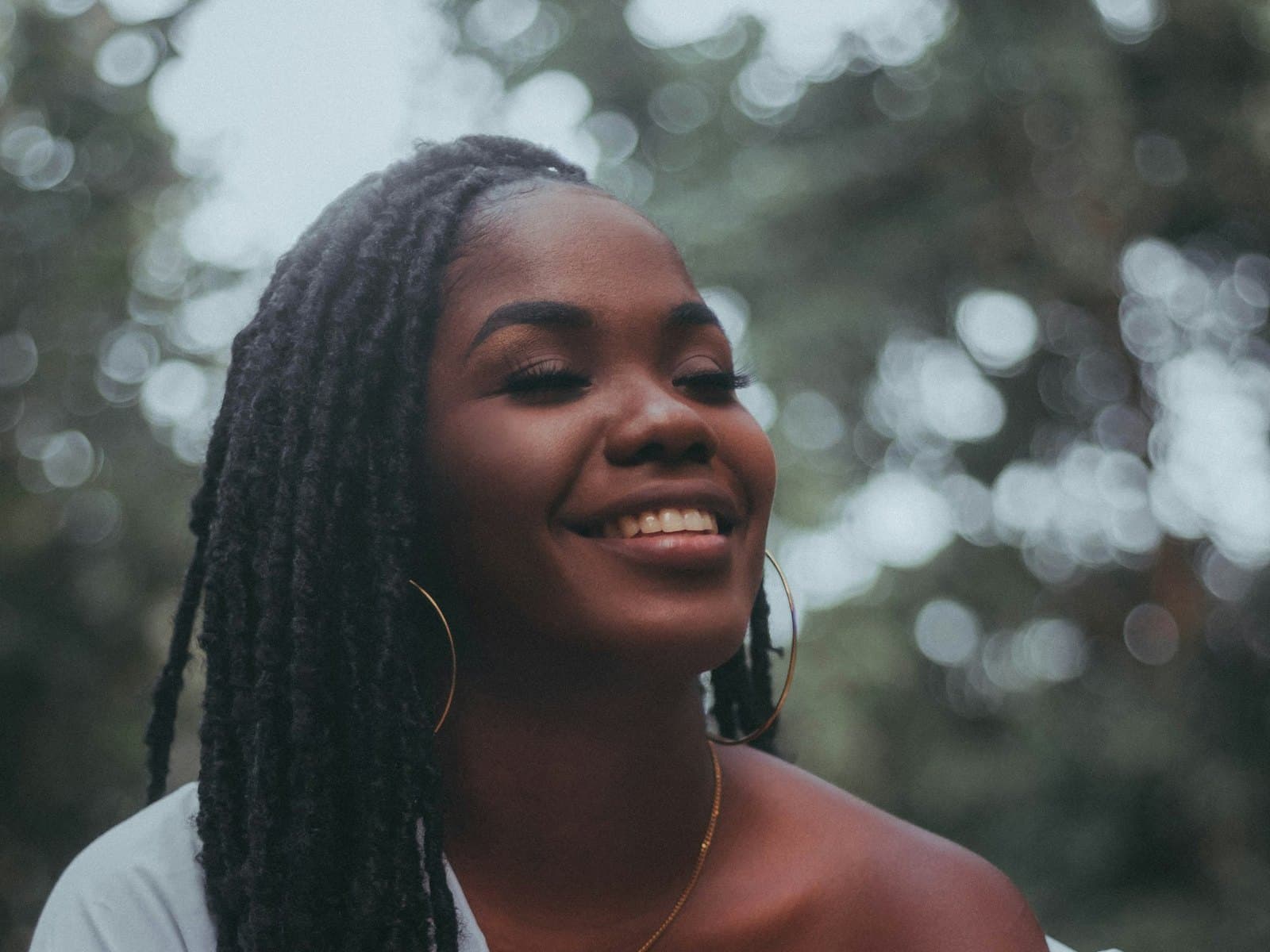 Smiling woman with locs in natural light — Allolocs